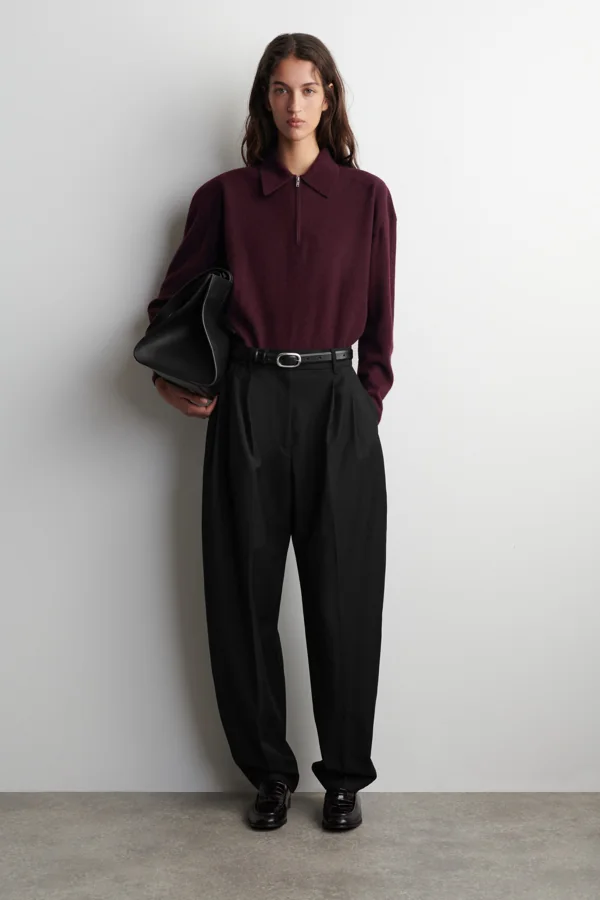 Burgundowy sweter COS 1321137001 z kołnierzem polo i zamkiem — widok z przodu na modelce. Dodatkowe elementy stylizacji z sesji producenta nie należą do opisywanego zestawu.