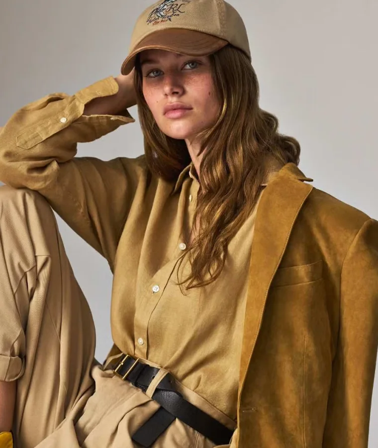 Modelka w piaskowej stylizacji Polo Ralph Lauren z czapką i paskiem.