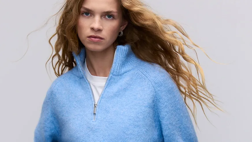 Modelka w jasnoniebieskim swetrze z krótkim zamkiem — zdjęcie Reserved.